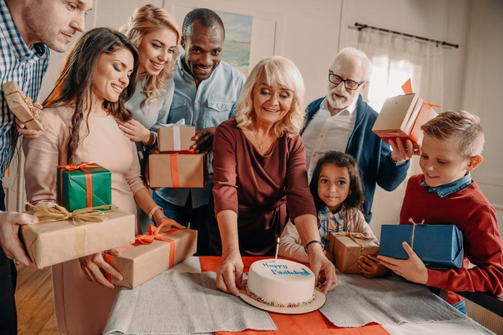 large family with birthday cake and gift boxes